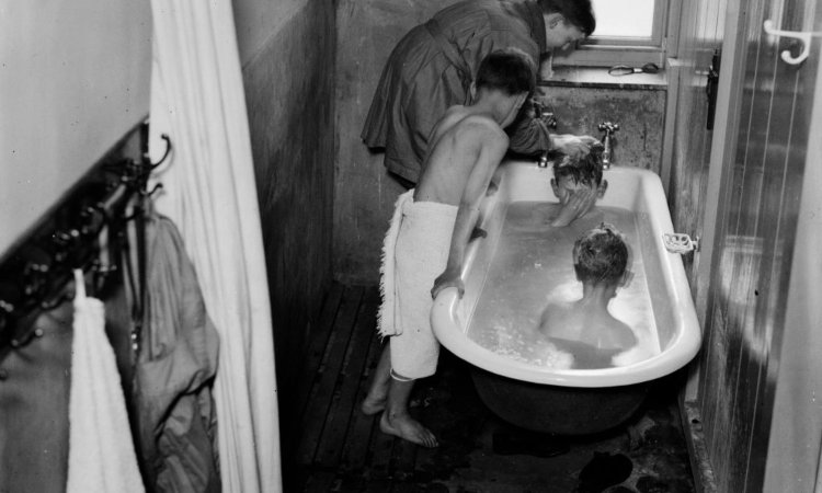 Dei bambini lavati dentro una vasca da bagno